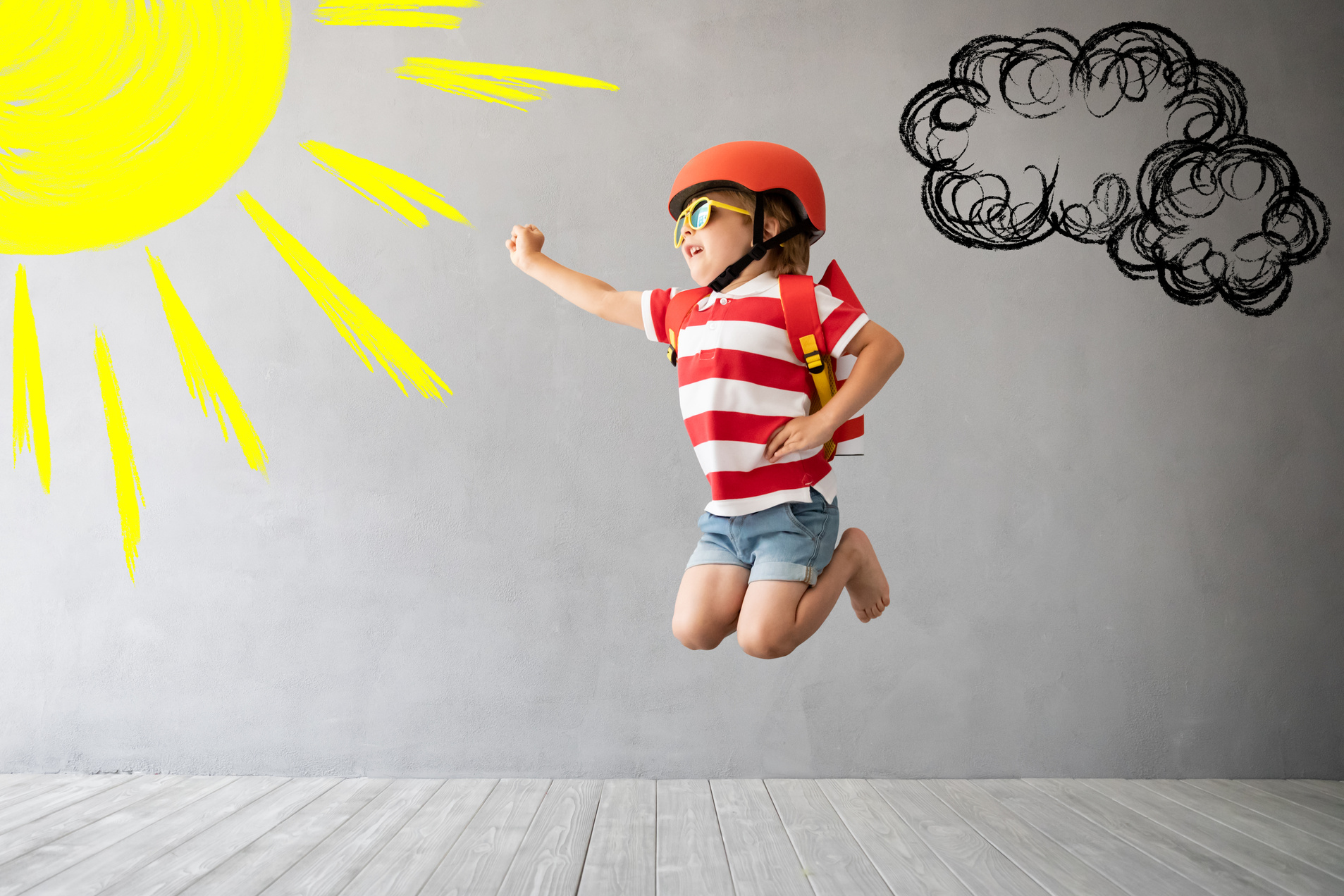 Child with Rocket Jumping against Grey Concrete Background